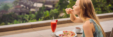 Woman eating delicious strawberry pizza on a balinese tropical natureの写真素材