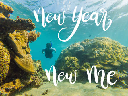 NEW YEAR NEW ME concept Happy man in snorkeling mask dive underwater with tropical fishes in coral reef sea pool. Travel lifestyle, water sport outdoor adventure, swimming lessons on summer beach holiday. Aerial view from the droneの写真素材