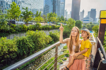 Mom and son tourists in Cheonggyecheon stream in Seoul, Korea. Cheonggyecheon stream is the result of a massive urban renewal project. Travel to Korea Conceptの写真素材