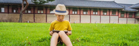 Young boy outdoors on the grass at backyard using his tablet computer.の写真素材