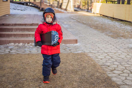 Little cute boy is ready for snowboarding. Activities for children in winter. Childrens winter sport. Lifestyleの写真素材