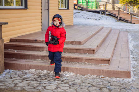 Little cute boy is ready for snowboarding. Activities for children in winter. Childrens winter...