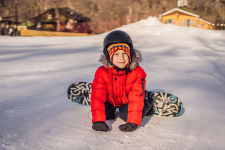 Little cute boy snowboarding. Activities for children in winter. Childrens winter sport. Lifestyleの写真素材