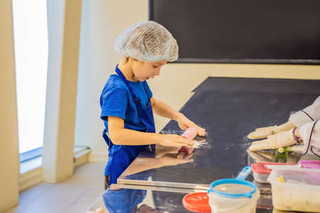 Kid boy enjoying preparing ingredients for making cakesの写真素材
