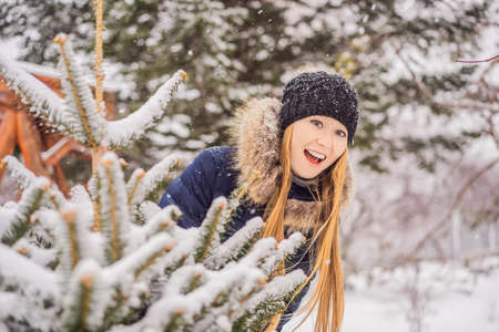 Young woman enjoys a winter snowy day in a snowy forest