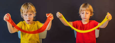 Twins play with hand made toy called slime. Children play with slime. Kids squeeze and stretching slimeの写真素材