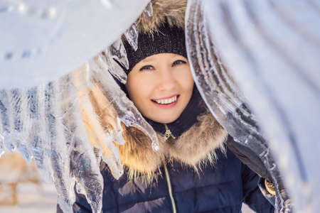 beautiful smiling young woman among the ice in wintertime outdoor. Winter conceptの写真素材