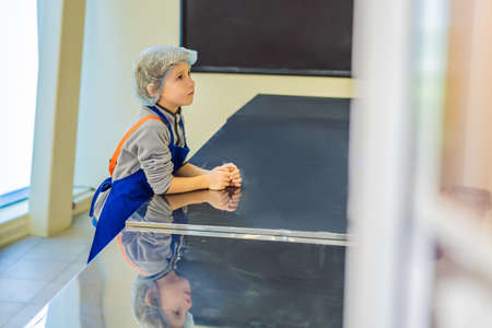 The boy plays the game as if he were a cook or a baker in a childrens kitchen
