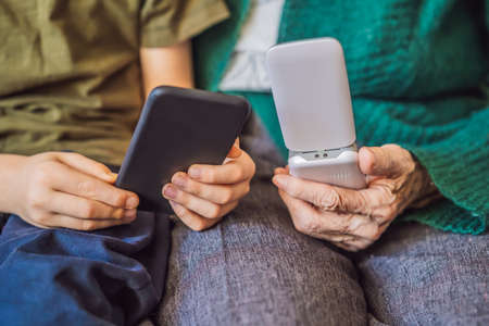 Old woman uses an old phone, boy uses a smartphone