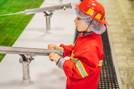 Expressive cute toddler with fireman outfit playing fireman