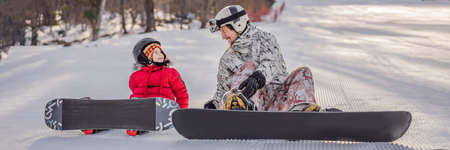 Dad teaches son snowboarding. Activities for children in winter. Childrens winter sport. Lifestyle...