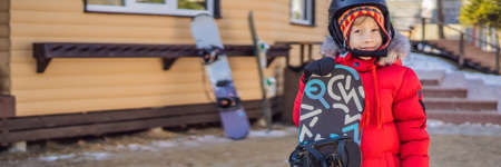 Little cute boy is ready for snowboarding. Activities for children in winter. Childrens winter sport. Lifestyle BANNER, LONG FORMATの写真素材