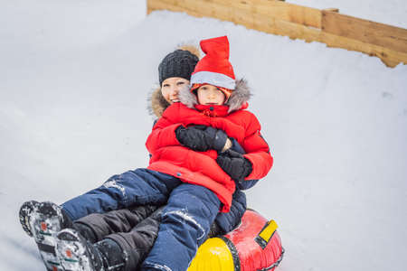 mom son ride on an inflatable winter sled tubing. Winter fun for the whole family