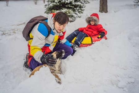 Dad and son have fun on tubing in the winter. Winter fun for the whole familyの写真素材