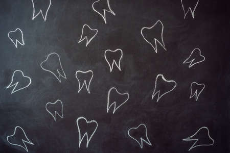 Teeth drawn in chalk on a black chalkboard. Dentistry Concept.