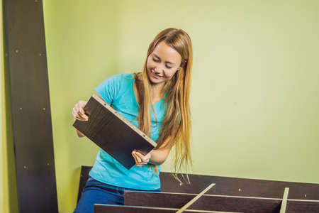 Caucasian woman using screwdriver for assembling furniture