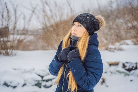 The woman was very froze in winter under snowfall. Winter problems