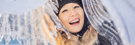 beautiful smiling young woman among the ice in wintertime outdoor. Winter concept BANNER, LONG...