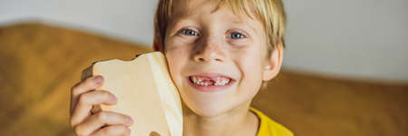 A boy, 6 years old, holds a box for milk teeth. Change of teeth BANNER, LONG FORMAT