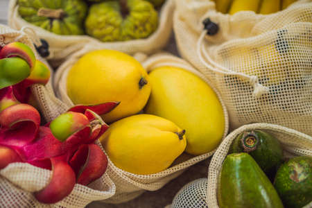 Fruit in a reusable bag on a stylish wooden kitchen surface. Zero waste concept, plastic free concept. Healthy clean eating diet and detox. Summer fruitsの写真素材