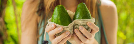 Avocado in a reusable bag in the hands of a young woman. Zero waste concept. BANNER, LONG FORMATの写真素材