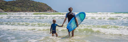 BANNER, LONG FORMAT Father or instructor teaching his son how to surf in the sea on vacation or...