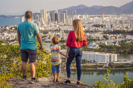 Happy family tourists on the background of Nha Trang city. Travel to Vietnam with kids Concept.の写真素材