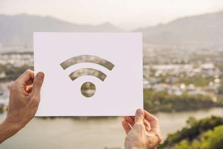 Wifi Internet icon in hands on a village backgroundの写真素材