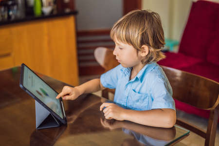 Boy studying online at home using tablet. Studying during quarantine. Global pandemic covid19 virus