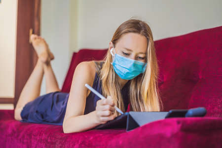 Woman is teaching drawing on a tablet at home in quarantine. Coronovirus, self-isolationの写真素材