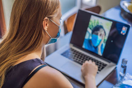 Coronavirus. Woman in quarantine for coronavirus wearing protective mask. Shes working from home and...
