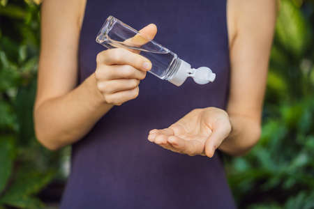 Womens hands using wash hand sanitizer gel