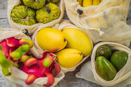 Fruit in a reusable bag on a stylish wooden kitchen surface. Zero waste concept, plastic free concept. Healthy clean eating diet and detox. Summer fruits.の写真素材