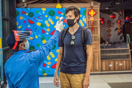 Vietnam, Nha Trang, 15.04.2020: Medical staff are checking the temperature of man. Before entering the area with an epidemic Covid-19のeditorial素材