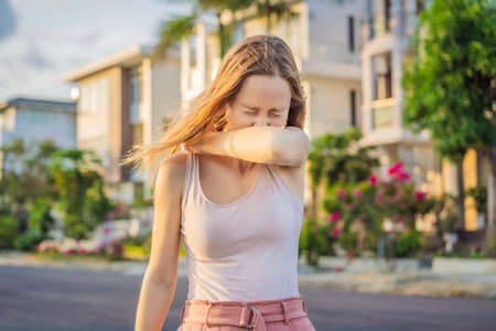 How to sneeze correctly. Woman sneezes on the elbow. Concept of the spread of the virus