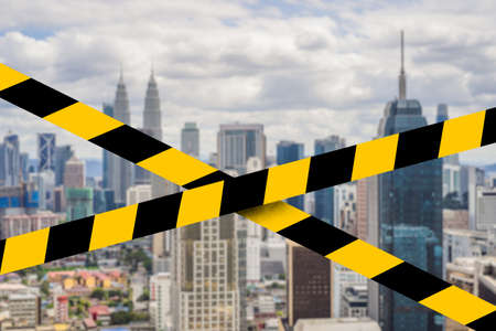 A panoramic aerial view of the Kuala Lumpur city during daylight Covid-19 quarantine yellow tape....