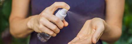 Womens hands using wash hand sanitizer gel BANNER, LONG FORMAT