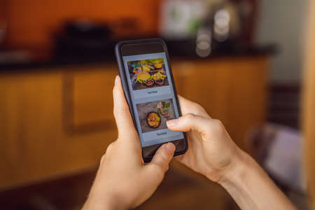 Young woman orders food for lunch online using a smartphone.