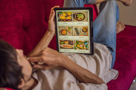 man orders food for lunch online using Tabletの写真素材