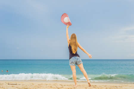Coronavirus is over. Quarantine weakened. Take off the mask. Now you can travel. Woman have fun on the beach watching the landing planes. Traveling on an airplane conceptの写真素材