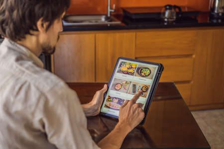 man orders food for lunch online using Tabletの写真素材