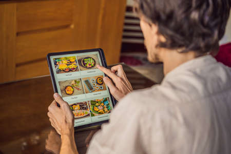 man orders food for lunch online using Tabletの写真素材