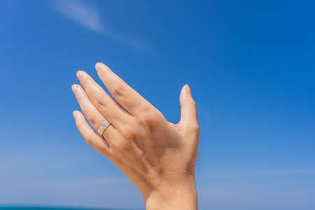 Coronavirus is over. Quarantine weakened. Take off the mask. Now you can travel. Female hand with a ring with a drawn plane holding a plane flying in the sky. Traveling on an airplane concept. Text space. Impressive paradise. Hot beach Mai Khao. Amazing landscapeの写真素材