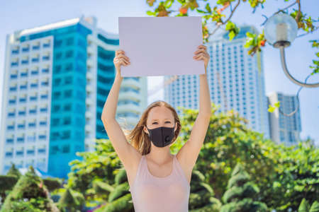 woman in medical mask prevents coronavirus disease holds a poster for free inscriptions.