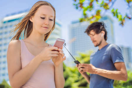 contact tracing app COVID-19 pandemic Coronavirus Mobile Application - people wearing face mask using smart phone App in City Street to Aid Contact Tracing in Response to the 2019-20 Coronavirus Pandemicの写真素材