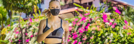 Woman runner wearing medical mask. Running in the park. Coronavirus pandemic Covid-19. Sport, Active life in quarantine surgical sterilizing face mask protection. Outdoor run on athletics track in Corona Outbreakの写真素材
