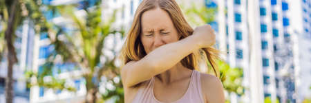 How to sneeze correctly. Woman sneezes on the elbow. Concept of the spread of the virusの写真素材