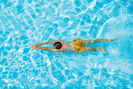 Young man swims in the pool, summer vacation conceptの写真素材