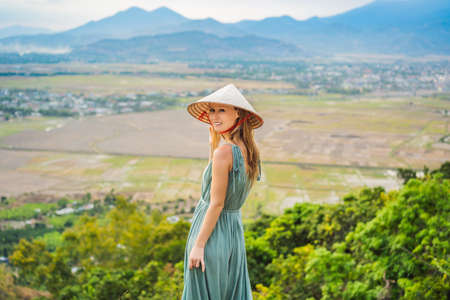 Young woman tourist in a traditional Vietnamese hat travels to Vietnamの写真素材