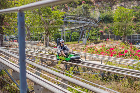 Vietnam, Nha Trang, 24.05.2020: People in medical masks after an epidemic of coronovirus on Rail downhill on a trolley, Point of view during a ride on Alpine Coaster on railsのeditorial素材